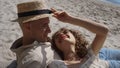 Carefree couple lying sand beach summer time close up. Girl putting hat on man. Royalty Free Stock Photo