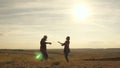 Carefree young girls and a man are dancing on field under the sun. Fun party at sunset. Happy woman and man dancing Royalty Free Stock Photo