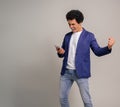 Carefree young man with afro hair and smart phone singing and playing air guitar on white background Royalty Free Stock Photo