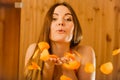 Carefree young woman blowing petals in sauna. Royalty Free Stock Photo