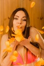 Carefree young woman blowing petals in sauna. Royalty Free Stock Photo