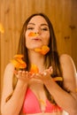 Carefree young woman blowing petals in sauna. Royalty Free Stock Photo