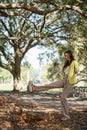 Carefree young woman kicking leaves in the park