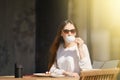 Carefree woman sitting on the terrace of the cafe and drinking cappuccino Royalty Free Stock Photo