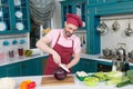 Careful chef smiling while cutting cabbage for a salad