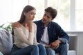 Careful european millennial man calms unhappy sad offended woman after quarrel in living room interior Royalty Free Stock Photo