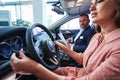 Careful female driver in the process of learning new car buttons Royalty Free Stock Photo