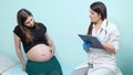 Careful doctor touches belly of pregnant woman in clinic Royalty Free Stock Photo