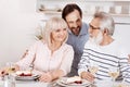 Careful mature son enjoying family dinner with parents at home