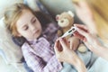 Careful Mom Sits Near Child and Holds Thermometer Royalty Free Stock Photo