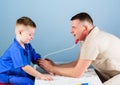 Careful pediatrician check health of kid. Medical examination. Hospital worker. Medical service. Man doctor sit table Royalty Free Stock Photo