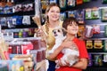 Careful preteen boy with mother visiting pet shop in search of treats for their dog Royalty Free Stock Photo