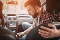 Careful young man is sitting besides his girlfriend and locking her seatbelt. He is looking down. Also guy is holding Royalty Free Stock Photo