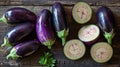 A carefully arranged composition of whole and sliced eggplants on a rustic wooden table Royalty Free Stock Photo