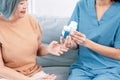 Caregiver advising contented senior woman on medication in the living room. Royalty Free Stock Photo