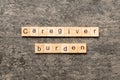 Caregiver burden word written on wood block. Caregiver burden text on cement table for your desing, concept Royalty Free Stock Photo