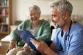 Caregiver doing regular check-up of senior woman in her home. Royalty Free Stock Photo