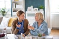 Caregiver or healthcare worker with senior woman patient, measuring blood glucose indoors.