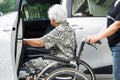 Caregiver help Asian elderly woman disability patient get in her car, medical concept