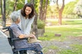 Caregiver help and care Asian senior or elderly old lady woman patient sitting and happy on wheelchair in park, healthy strong Royalty Free Stock Photo