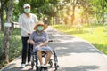 Caregiver help and care Asian senior or elderly old lady woman patient sitting on wheelchair and wear a face mask to travel in Royalty Free Stock Photo