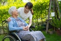 caregiver help and care Asian senior woman patient sitting on wheelchair at nursing hospital, healthy strong medical Royalty Free Stock Photo