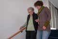 Senior woman going down stairs with helping hands of young woman Royalty Free Stock Photo