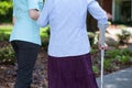 Caregiver helping woman with a crutch