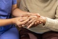 Caregiver massaging finger of elderly woman in painful swollen gout