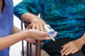 Caregiver monitoring oxygen of elderly woman