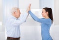 Caregiver and senior man giving high five