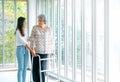 Caregiver, smiling young Asian female, daughter or grandchild supporting help elderly woman, mother or grandparents try to walk.