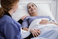 caregiver supporting sick woman with leukemia in the hospital