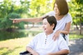 Caregiver take care to elderly asian woman sitting on wheelchair at nature,Senior care insurance concept