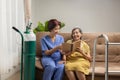 Caregiver takecare elderly woman while wearing oxygen nasal cannula at home