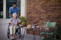 Caregiver taking his senior client at breakfast outdoor in the city. Royalty Free Stock Photo