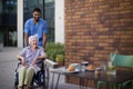 Caregiver taking his senior client at breakfast outdoor in the city. Royalty Free Stock Photo