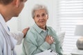 Caregiver talking to senior woman in living room. Home health care service Royalty Free Stock Photo