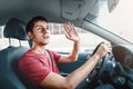 Careless car driver raises his hand in thanks for giving way. Traffic rules and politeness concept Royalty Free Stock Photo