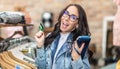 Careless shopaholic fmeale customer holds purse and credit card with happy expression inside the fashion store Royalty Free Stock Photo