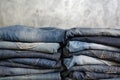 Carelessly folded jeans in two piles on a gray background. Close-up of jeans in different colors. Copy space Royalty Free Stock Photo