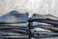 Carelessly folded jeans in two piles on a gray background. Close-up of jeans in different colors. Copy space Royalty Free Stock Photo