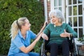 Carer Pushing Senior Woman In Wheelchair Outside Home Royalty Free Stock Photo