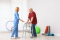 Caretaker helping elderly man with walking frame Royalty Free Stock Photo