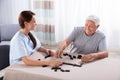 Caretaker Looking At Elder Man Playing Dominoes Royalty Free Stock Photo