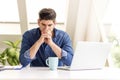 Careworn businessman sitting at office desk behind his laptop Royalty Free Stock Photo