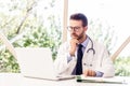 Careworn male doctor working on laptop and desk in the hospital Royalty Free Stock Photo