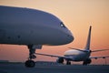 Cargo airplane is taxiing behind passenger airplane at busy airport