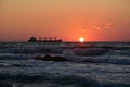 Black silhouette of ship at sunrise