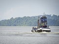 Cargo boat floats on the sea laden with barrels of water, Thailand